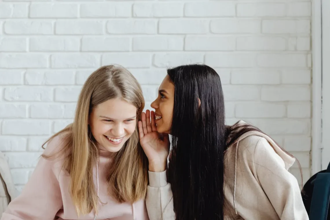 Socialkonstruktionisme 2 kvinder hvisker til hinanden