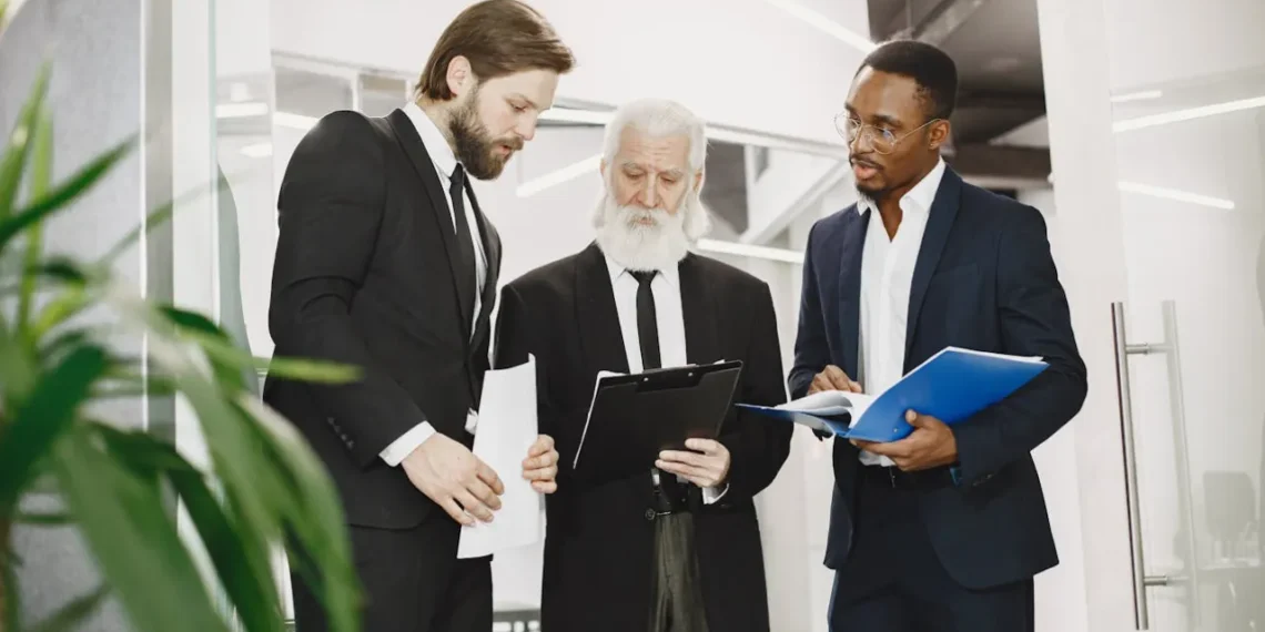 Blake og Moutons ledergitter - gråhåret chef gennemgår teorien med 2 medarbejdere