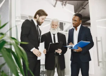 Blake og Moutons ledergitter - gråhåret chef gennemgår teorien med 2 medarbejdere