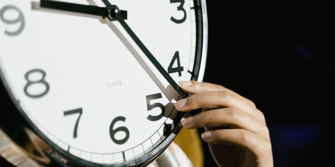 Hånd stiller på nærbillede af ur som udtryk for manipulation