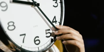 Hånd stiller på nærbillede af ur som udtryk for manipulation