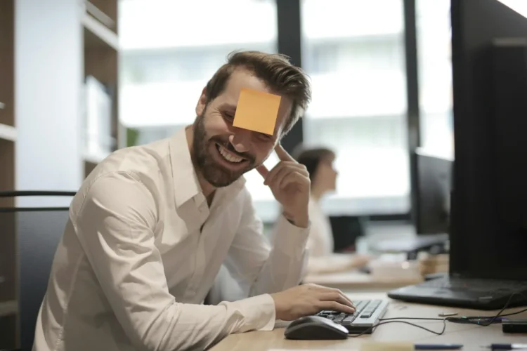MUS-samtale medarbejder - medarbejder sidder med post-it i panden og griner