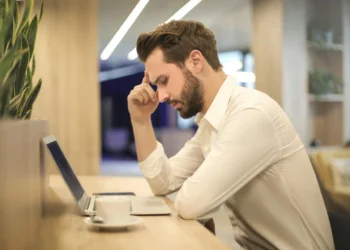 Mand kigger fortvivlet ned i computer efter sin fyring