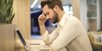 Mand kigger fortvivlet ned i computer efter sin fyring