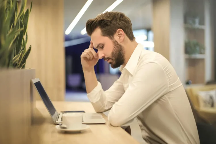 Mand kigger fortvivlet ned i computer efter sin fyring