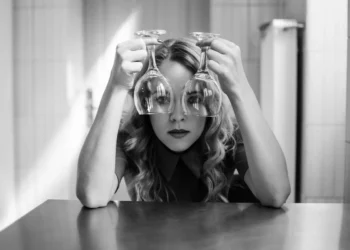 Pige kigger ud gennem 2 vinglas som metafor for narcissisme