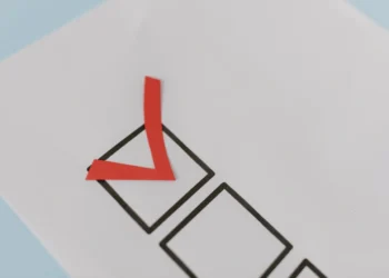 Rødt check-mark i sort firkant som i vellykket forandringsledelse