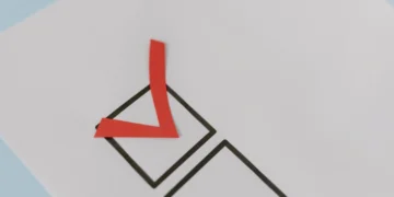 Rødt check-mark i sort firkant som i vellykket forandringsledelse