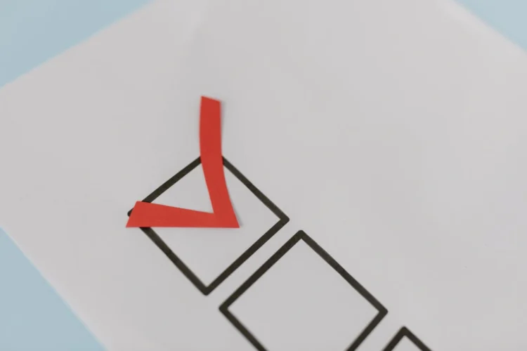 Rødt check-mark i sort firkant som i vellykket forandringsledelse