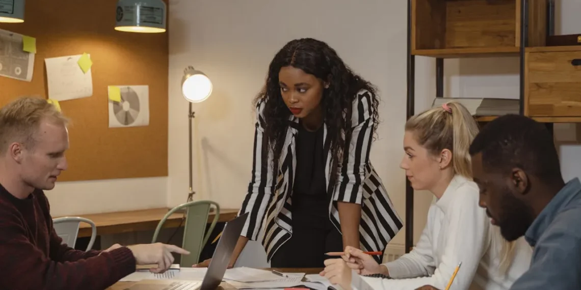 Teamledelse - her sidder et velfungerende team til bords. Leder står dog op.