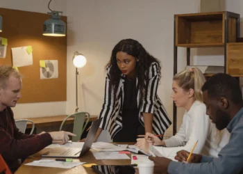 Teamledelse - her sidder et velfungerende team til bords. Leder står dog op.