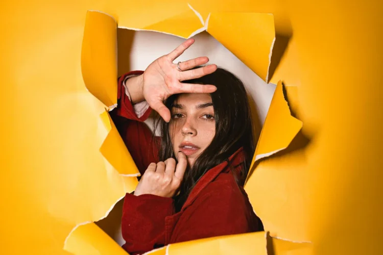 ung kvinde gennembryder gult tapet som positivt synonym for at være introvert