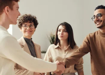 2 kvinder og 2 mænd giver håndslag som udtryk for assertiv kommunikation.