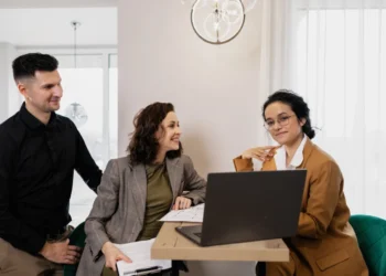3 mennesker rundt om en pc som systemisk coaching