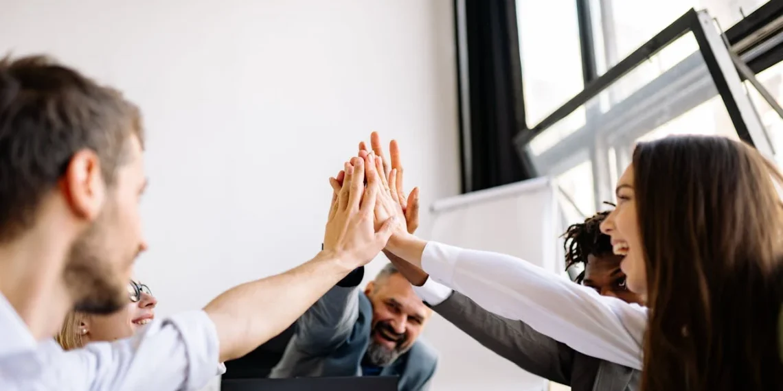 5 personer giver high five på kontoret