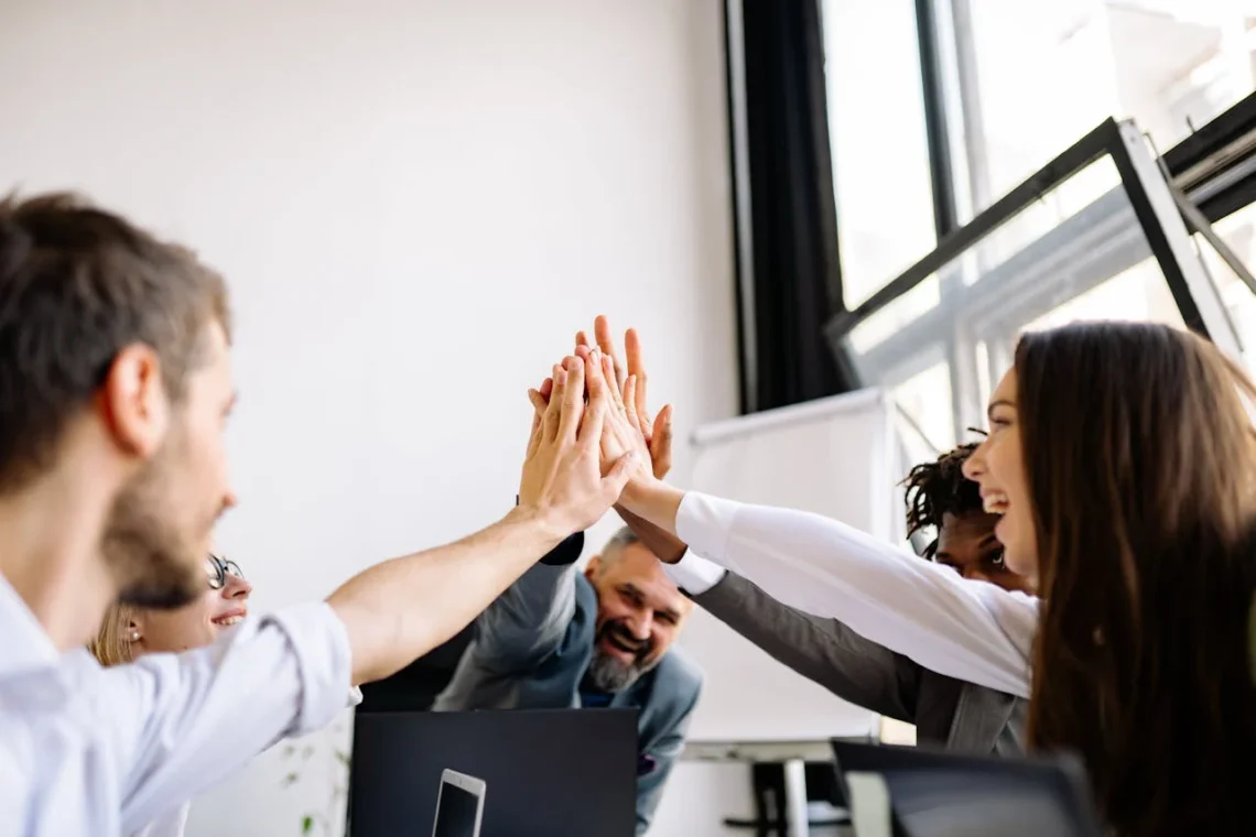 5 personer giver high five på kontoret