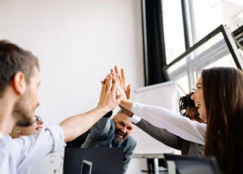 5 personer giver high five på kontoret