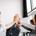 5 personer giver high five på kontoret