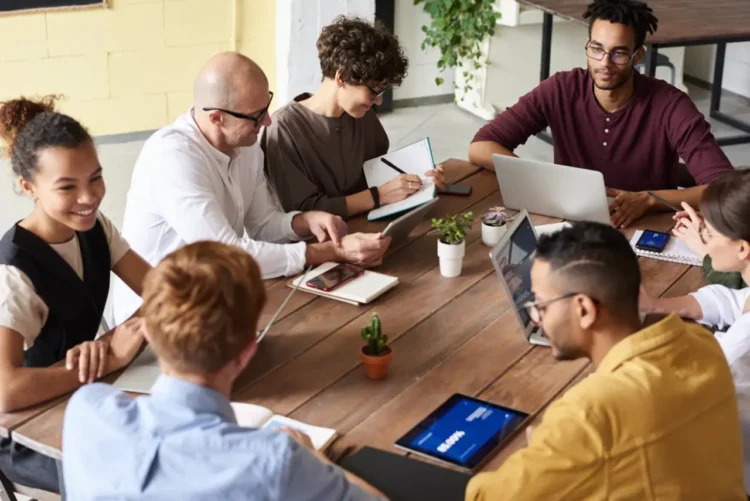 7 mennesker omkring et arbejdsbord som i netværk.