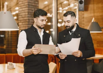 Chef og souschef står i kantinen og koordinerer.