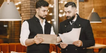 Chef og souschef står i kantinen og koordinerer.