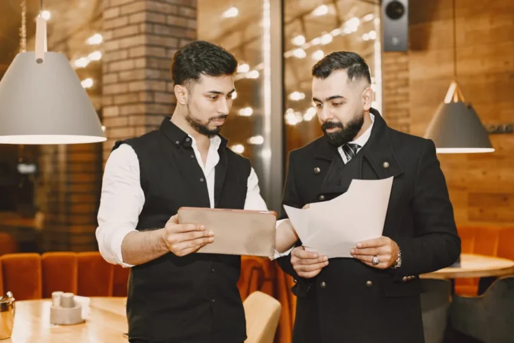 Chef og souschef står i kantinen og koordinerer.