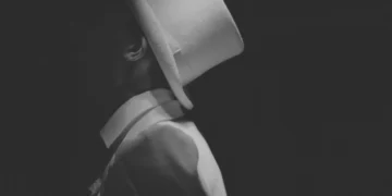 Den manipulerende leder her iklædt hvidt jakkesæt og hvid har med skjult ansigt