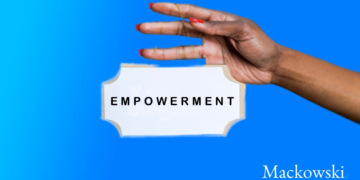 Hånd holder skilt med empowerment skrevet på skiltet