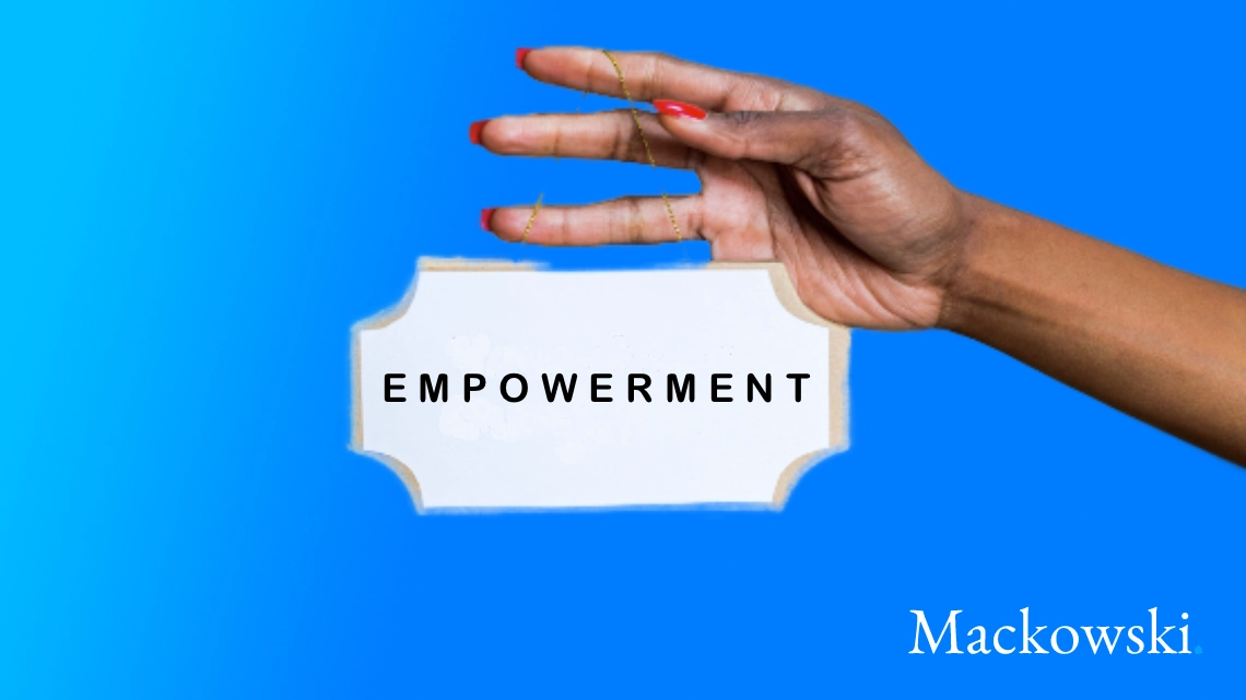 Hånd holder skilt med empowerment skrevet på skiltet