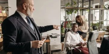 Karismatisk leder peger på medarbejder som sidder ned.