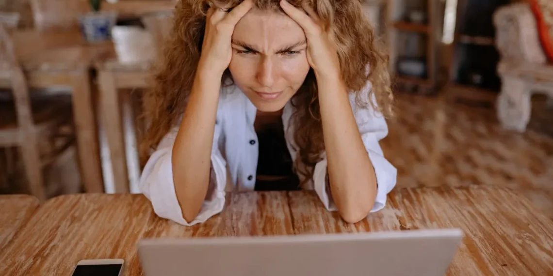 Kvinde kigger mistroisk på sin computer efter afskedigelse