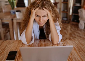 Kvinde kigger mistroisk på sin computer efter afskedigelse