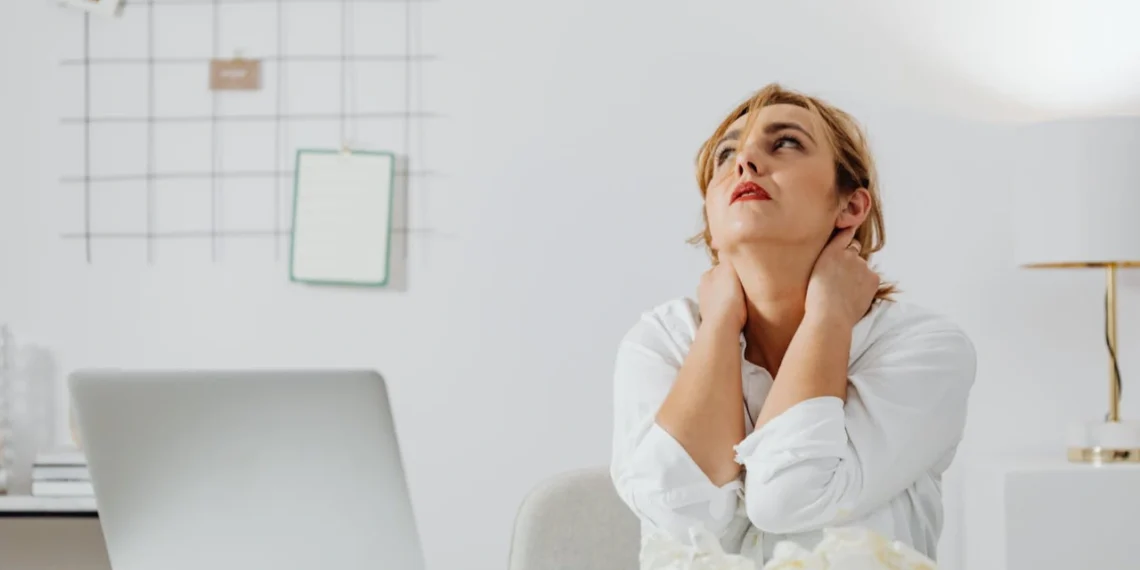 Kvinde med hænderne bag nakken som i forsøg på stresshåndtering (stresshaandtering).