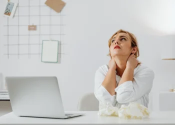 Kvinde med hænderne bag nakken som i forsøg på stresshåndtering (stresshaandtering).
