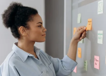 Kvinde skal prioritere på tavle med post-its