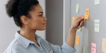 Kvinde skal prioritere på tavle med post-its