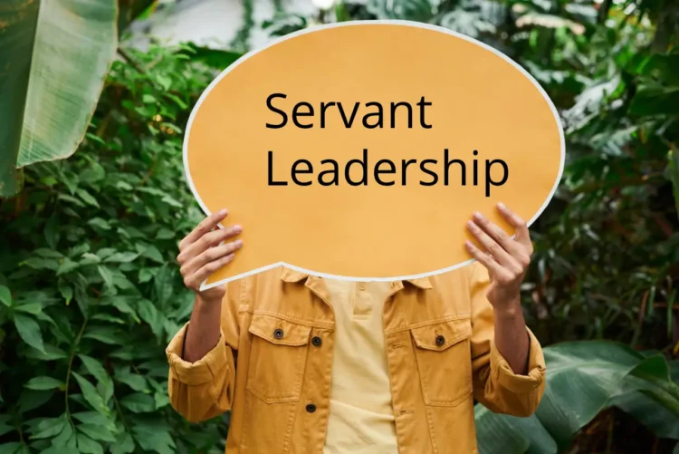 Mand holder orange skilt op med Servant Leadership
