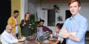 Mand i forgrunden for arbejdsgruppe som i paradoksledelse