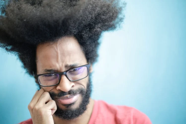 Mand med kæmpe mikrofonhår er tydeligt i et følelsesmæssigt dilemma