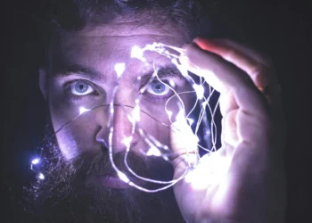 Mand står med lysende hånd som udtryk for intuition.