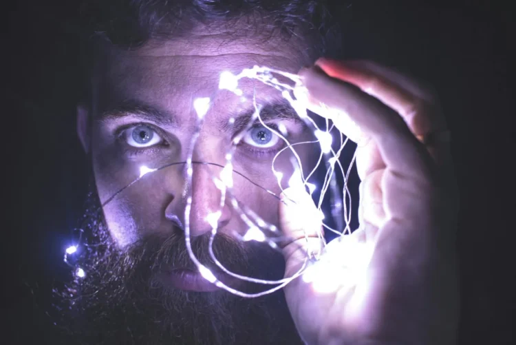 Mand står med lysende hånd som udtryk for intuition.