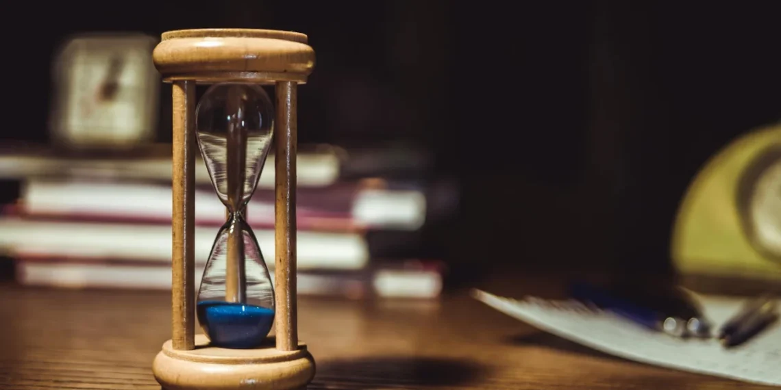 Timeglas med blå sand i som udtryk for prøvetid.