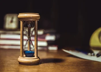 Timeglas med blå sand i som udtryk for prøvetid.