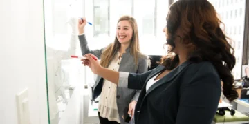 To kvinder ved whiteboard som i engagement.