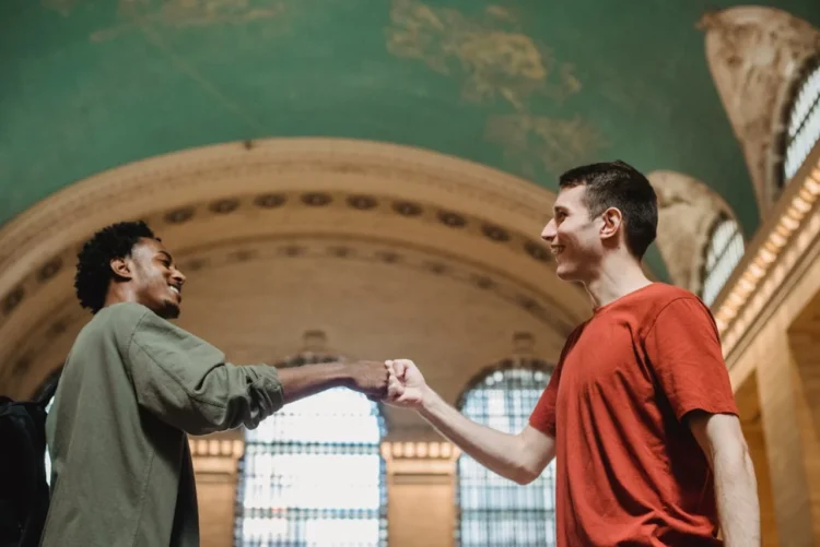 To mænd giver hinanden ros med knoer mod hinanden i italiensk katedral.