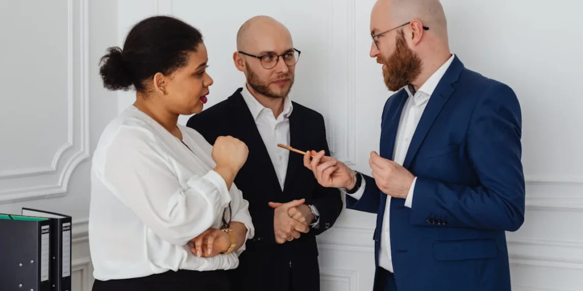 To mænd og en kvinde samtaler om personligt lederskab.