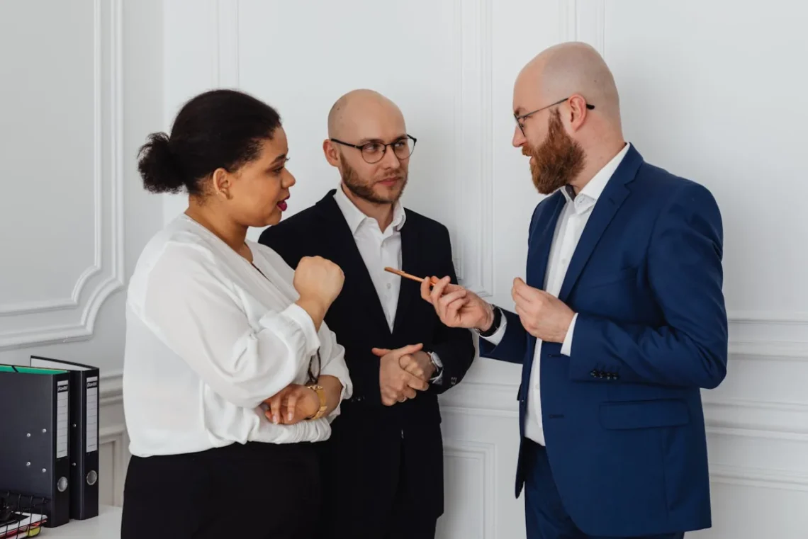 To mænd og en kvinde samtaler om personligt lederskab.