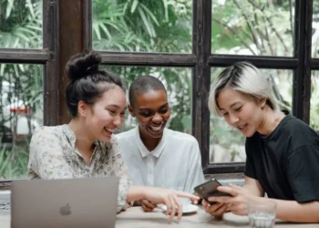 Tre kvinder rundt om en MacBook som i generationsledelse