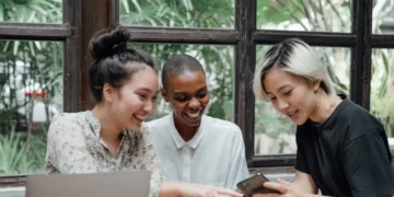 Tre kvinder rundt om en MacBook som i generationsledelse