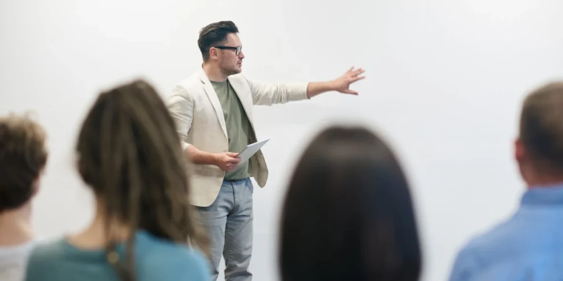 Underviser set mellem rækker af studerende underviser i storytelling på tavlen.